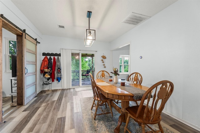 703 Pecan Valley Dr, Wharton, TX 77488 - dining area featuring a barn door and wood finished floors