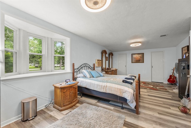 703 Pecan Valley Dr, Wharton, TX 77488 - bedroom featuring wood finished floors and a textured ceiling