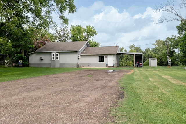 703 Pecan Valley Dr, Wharton, TX 77488 - rear view of house with a carport, a lawn, dirt driveway, and stucco siding