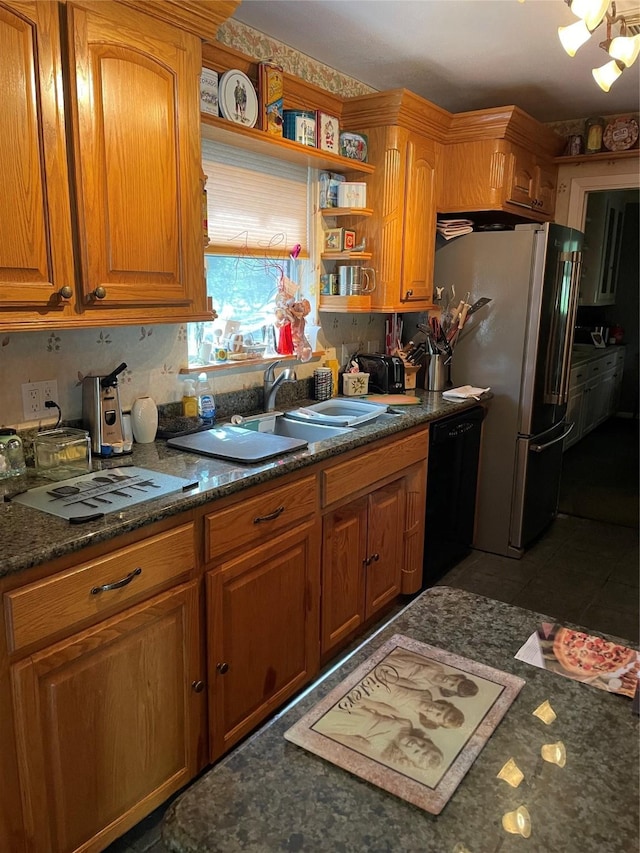 507 Oak Dr, Lake Jackson, TX 77566 - kitchen with black dishwasher, freestanding refrigerator, brown cabinetry, and open shelves