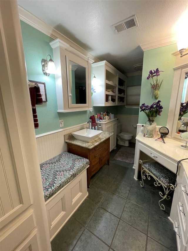 507 Oak Dr, Lake Jackson, TX 77566 - bathroom featuring crown molding, wainscoting, a textured ceiling, vanity, and tile patterned flooring