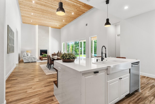 25203 Elijah Ct, Tomball, TX 77375 - kitchen with stainless steel dishwasher, high vaulted ceiling, wooden ceiling, a fireplace, and open floor plan