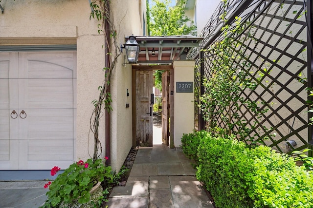 2207 Dunraven Ln, Houston, TX 77019 - doorway to property featuring stucco siding, a gate, and a garage