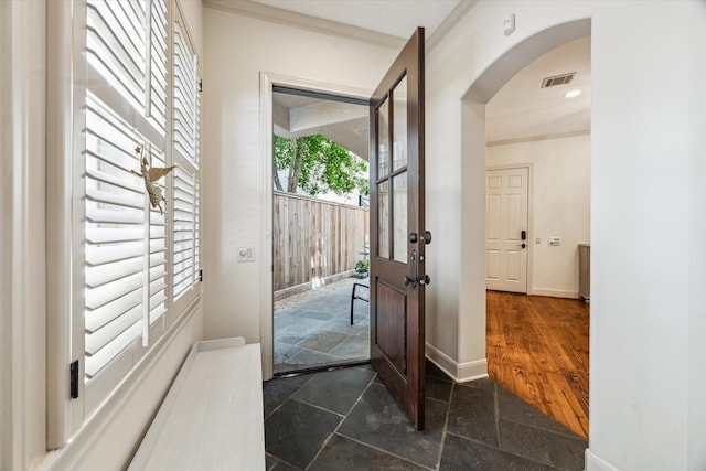 2207 Dunraven Ln, Houston, TX 77019 - foyer entrance featuring stone tile flooring, arched walkways, and crown molding