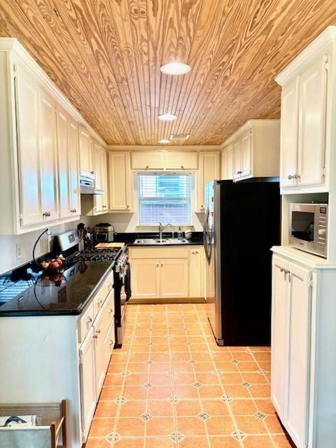 9618 Chatfield St, Houston, TX 77025 - kitchen with stainless steel appliances, wood ceiling, under cabinet range hood, dark countertops, and white cabinetry
