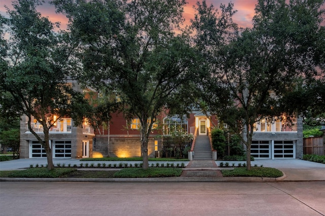 3211 Pittsburg St, West University Place, TX 77005 - view of property hidden behind natural elements with concrete driveway, a garage, stairs, stone siding, and a balcony