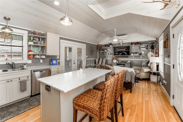 210 N Scott St, Fayetteville, TX 78940 - kitchen featuring stainless steel dishwasher, vaulted ceiling, french doors, light wood-style floors, and a breakfast bar area