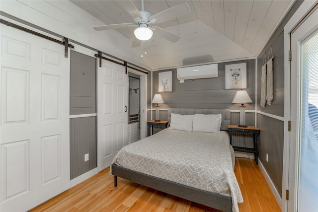 210 N Scott St, Fayetteville, TX 78940 - bedroom with a wall mounted air conditioner, a barn door, wood finished floors, vaulted ceiling, and wooden ceiling