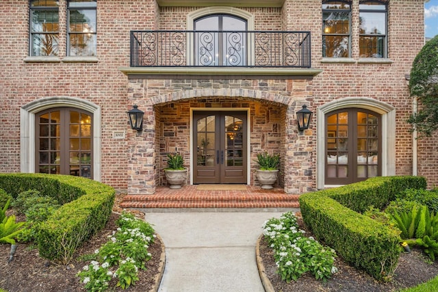1002 Cowards Creek Ct, Friendswood, TX 77546 - view of exterior entry featuring french doors, a balcony, and brick siding