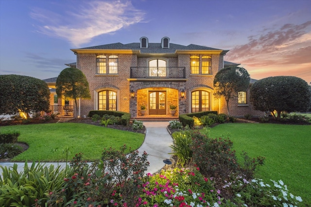 1002 Cowards Creek Ct, Friendswood, TX 77546 - view of front facade with french doors, a balcony, brick siding, and a front yard