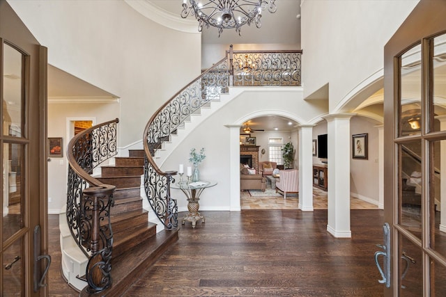 1002 Cowards Creek Ct, Friendswood, TX 77546 - foyer featuring decorative columns, arched walkways, wood finished floors, a high ceiling, and stairs