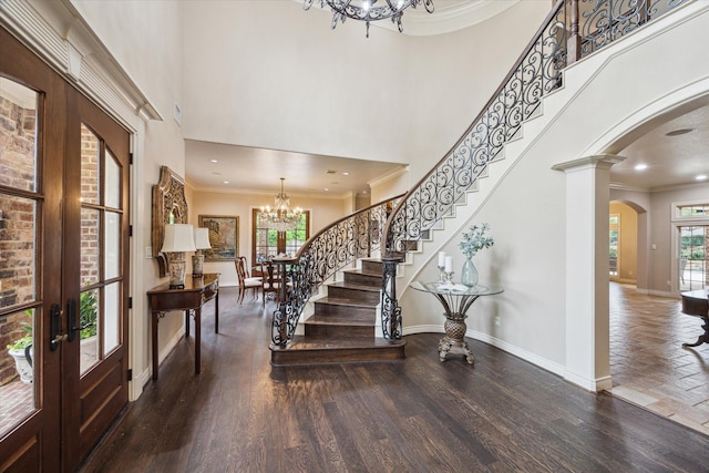 1002 Cowards Creek Ct, Friendswood, TX 77546 - foyer entrance featuring a chandelier, arched walkways, ornamental molding, stairs, and a towering ceiling