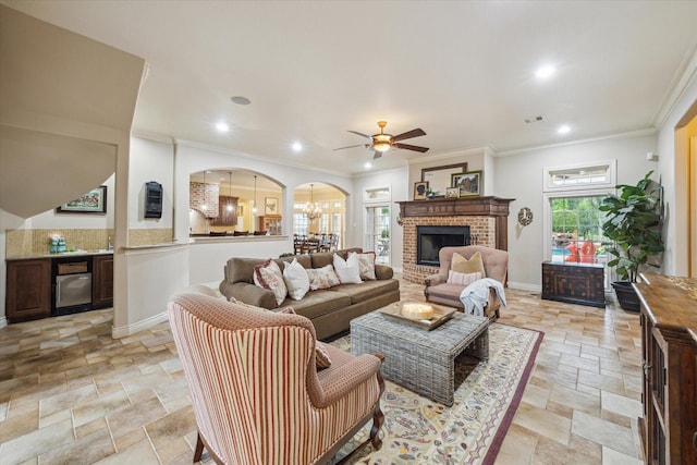 1002 Cowards Creek Ct, Friendswood, TX 77546 - living room featuring stone tile flooring, a ceiling fan, arched walkways, crown molding, and recessed lighting