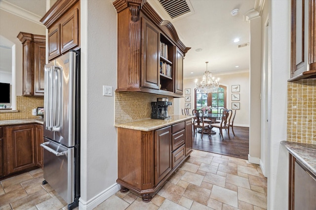 1002 Cowards Creek Ct, Friendswood, TX 77546 - kitchen featuring high end fridge, crown molding, tasteful backsplash, light stone finish flooring, and a chandelier