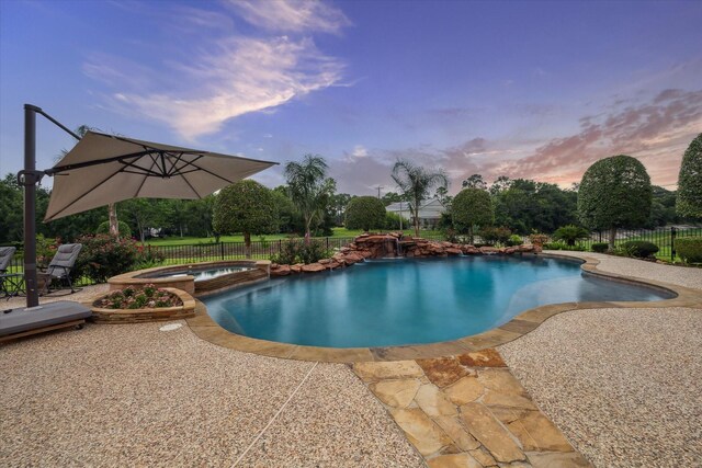1002 Cowards Creek Ct, Friendswood, TX 77546 - pool at dusk with a patio and a pool with connected hot tub