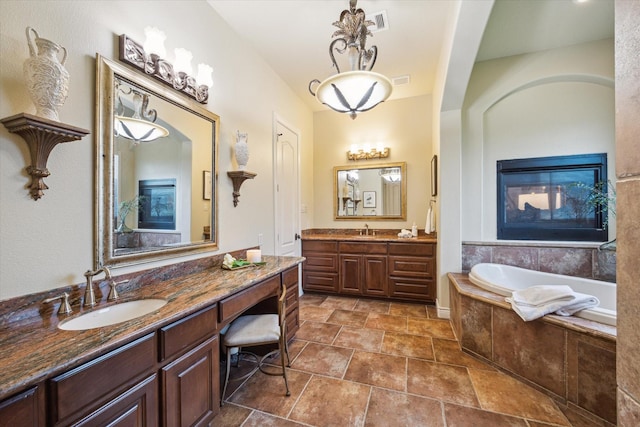 1002 Cowards Creek Ct, Friendswood, TX 77546 - bathroom featuring a bath, two vanities, and stone finish flooring