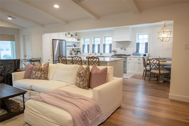7611 Fairdale Ln, Houston, TX 77063 - living area featuring a chandelier, beam ceiling, wood finished floors, and recessed lighting