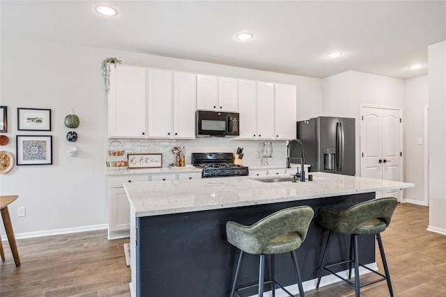13110 Mid Stocket Dr, Humble, TX 77346 - kitchen with black microwave, stove, stainless steel fridge, backsplash, and recessed lighting