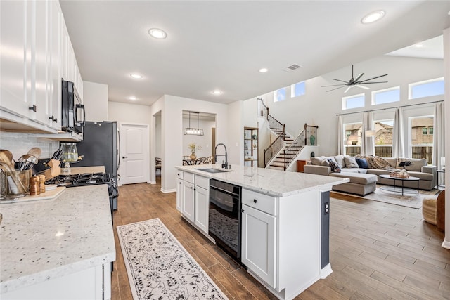 13110 Mid Stocket Dr, Humble, TX 77346 - kitchen featuring stainless steel microwave, dishwasher, white cabinetry, wood finished floors, and a ceiling fan
