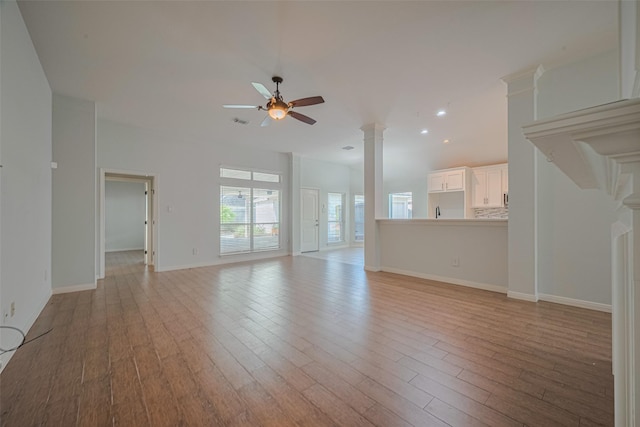 11607 Buck Springs Trl, Tomball, TX 77377 - unfurnished living room featuring a ceiling fan, light wood finished floors, decorative columns, and recessed lighting