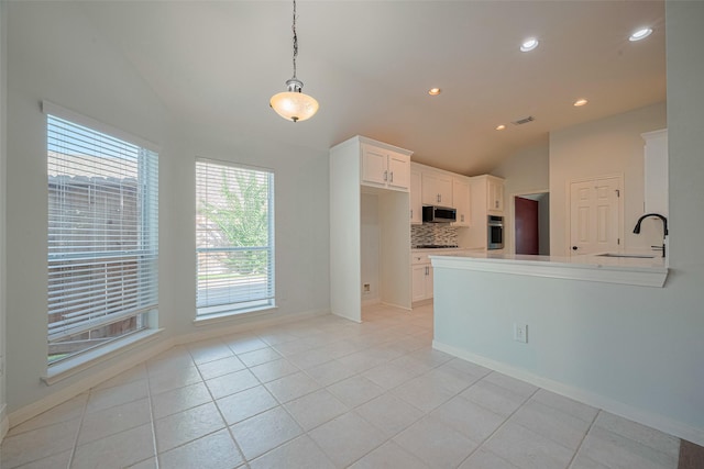 11607 Buck Springs Trl, Tomball, TX 77377 - kitchen featuring appliances with stainless steel finishes, lofted ceiling, tasteful backsplash, white cabinets, and recessed lighting