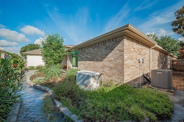 11607 Buck Springs Trl, Tomball, TX 77377 - view of home's exterior with a central AC unit and brick siding