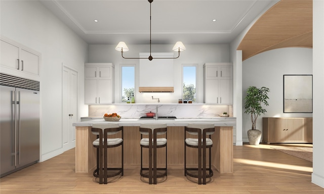 1002 E 25th St, Houston, TX 77009 - kitchen with built in refrigerator, a center island, light countertops, and white cabinetry