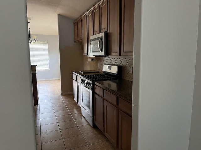 12610 Bethany Bay Dr, Pearland, TX 77584 - kitchen with stainless steel appliances, tasteful backsplash, dark tile patterned flooring, and a chandelier