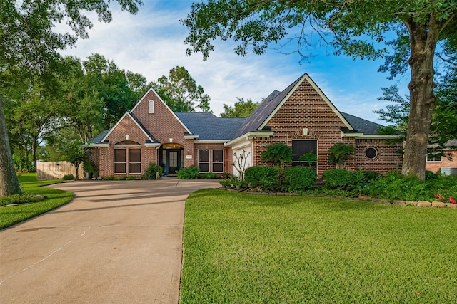 14311 Cally Cir, Needville, TX 77461 - view of front of house with driveway, brick siding, a front lawn, a shingled roof, and an attached garage