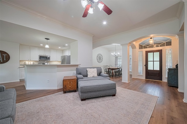 14311 Cally Cir, Needville, TX 77461 - living room with arched walkways, decorative columns, wood finished floors, a ceiling fan, and crown molding