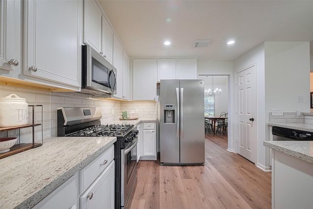 14311 Cally Cir, Needville, TX 77461 - kitchen featuring appliances with stainless steel finishes, light wood-style flooring, white cabinets, backsplash, and recessed lighting