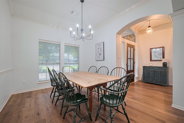 14311 Cally Cir, Needville, TX 77461 - dining area featuring arched walkways, crown molding, wood finished floors, and a chandelier