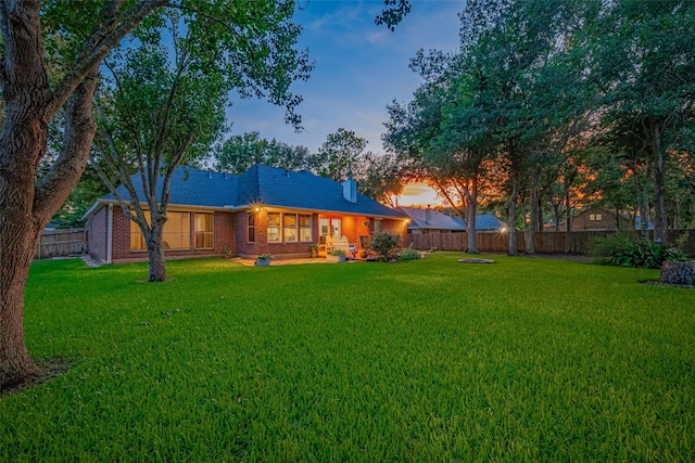 14311 Cally Cir, Needville, TX 77461 - back of property at dusk featuring a fenced backyard and brick siding
