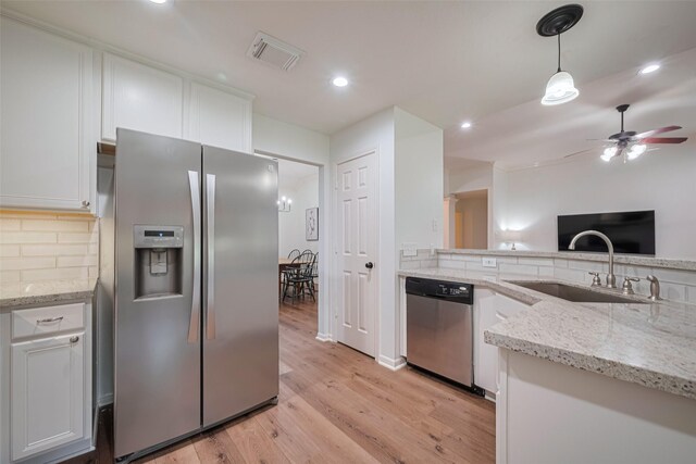 14311 Cally Cir, Needville, TX 77461 - kitchen featuring stainless steel appliances, a ceiling fan, white cabinets, decorative backsplash, and light wood-style flooring
