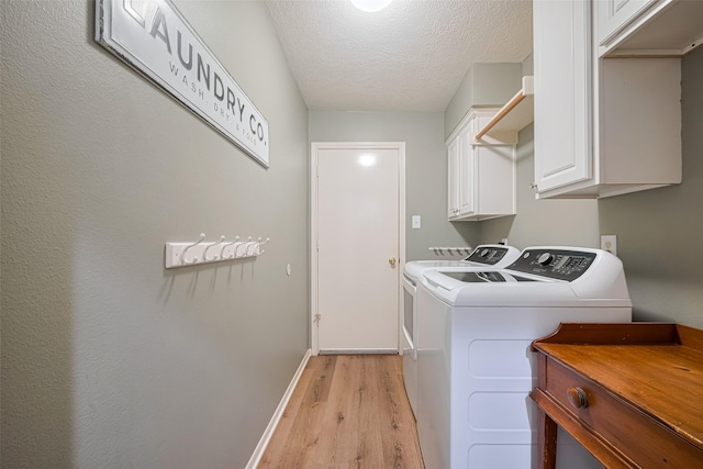 14311 Cally Cir, Needville, TX 77461 - laundry room with independent washer and dryer, light wood-type flooring, cabinet space, and a textured ceiling