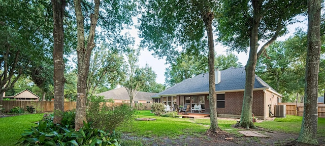14311 Cally Cir, Needville, TX 77461 - rear view of house with a fenced backyard, a shingled roof, brick siding, and a patio area