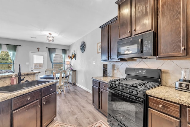 10211 Norway Spruce Ln, Tomball, TX 77375 - kitchen with black appliances, plenty of natural light, backsplash, and light wood-style flooring