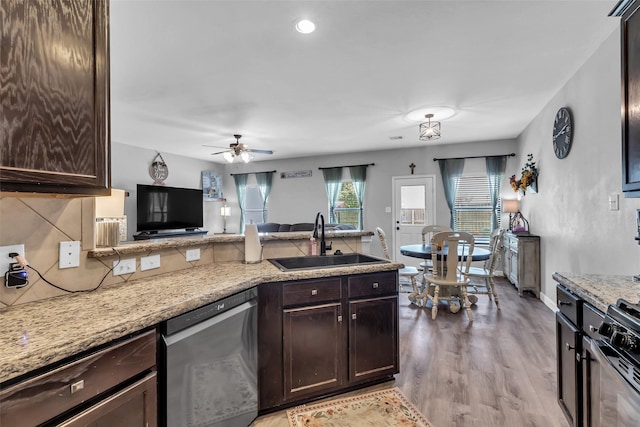 10211 Norway Spruce Ln, Tomball, TX 77375 - kitchen featuring stainless steel dishwasher, dark brown cabinets, light wood-style flooring, a peninsula, and backsplash