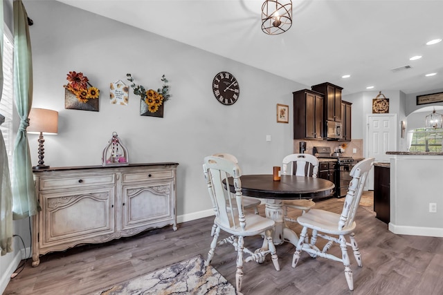 10211 Norway Spruce Ln, Tomball, TX 77375 - dining room with light wood-type flooring, recessed lighting, healthy amount of natural light, and arched walkways