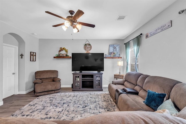 10211 Norway Spruce Ln, Tomball, TX 77375 - living room featuring arched walkways, a ceiling fan, and wood finished floors