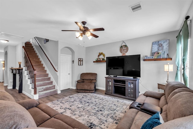 10211 Norway Spruce Ln, Tomball, TX 77375 - living area featuring arched walkways, stairway, a ceiling fan, and wood finished floors