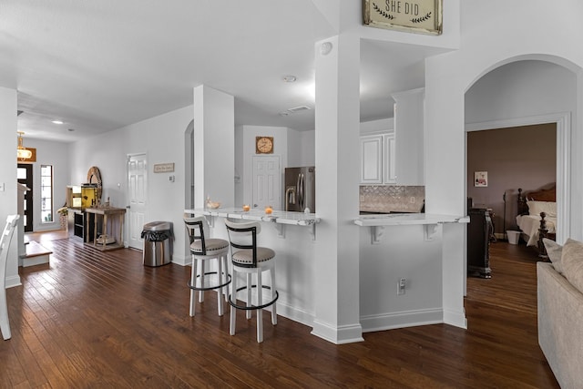 6006 Gilman Trace Ln, Houston, TX 77092 - kitchen featuring stainless steel refrigerator with ice dispenser, a peninsula, a breakfast bar area, and light countertops