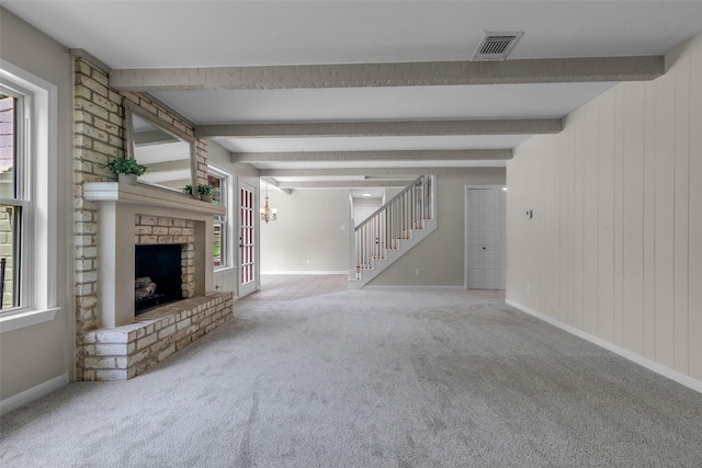 6415 Bayonne Dr, Spring, TX 77389 - unfurnished living room with carpet floors, stairway, plenty of natural light, and beamed ceiling