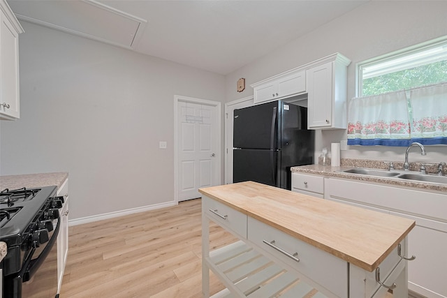 12118 Dumas St, Houston, TX 77034 - kitchen with black appliances, wooden counters, white cabinets, light wood-style flooring, and a center island