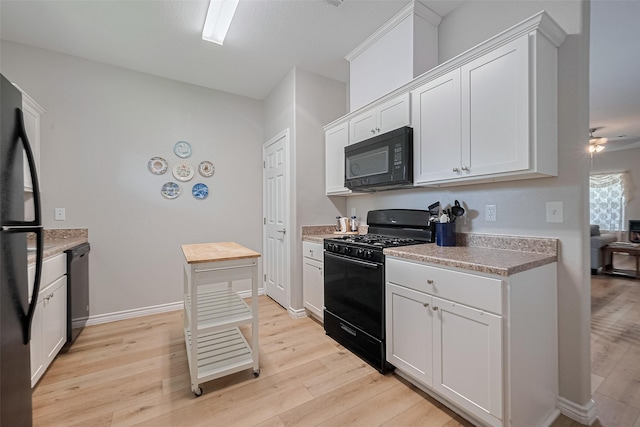 12118 Dumas St, Houston, TX 77034 - kitchen featuring black appliances, light wood-style flooring, white cabinetry, and light countertops