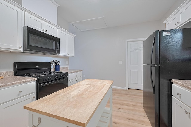 12118 Dumas St, Houston, TX 77034 - kitchen featuring black appliances, light wood finished floors, white cabinetry, and a center island