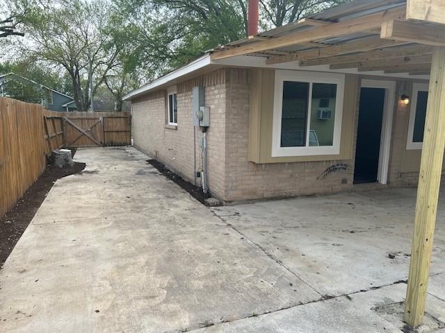 15834 Bazelbriar Ln, Houston, TX 77489 - view of side of home featuring brick siding, a gate, and a patio area