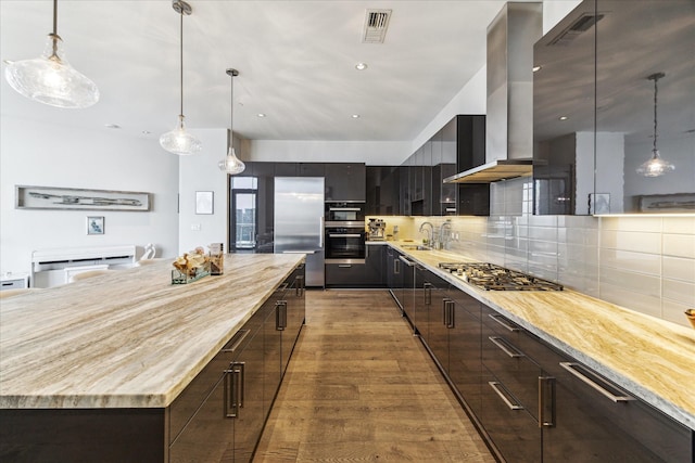 1409 Post Oak Blvd Unit 2204, Houston, TX 77056 - kitchen with stainless steel appliances, wall chimney exhaust hood, modern cabinets, backsplash, and hanging light fixtures