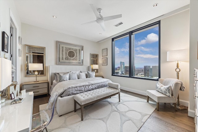 1409 Post Oak Blvd Unit 2204, Houston, TX 77056 - bedroom with wood finished floors, a ceiling fan, and a city view