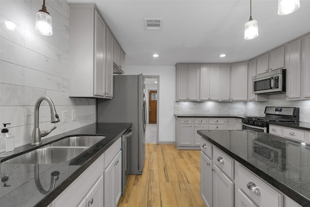 2934 Robertson St, Houston, TX 77009 - kitchen with stainless steel appliances, tasteful backsplash, light wood-style flooring, decorative light fixtures, and recessed lighting
